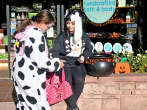 A Salus employee hands out treats from a witch’s cauldron.
