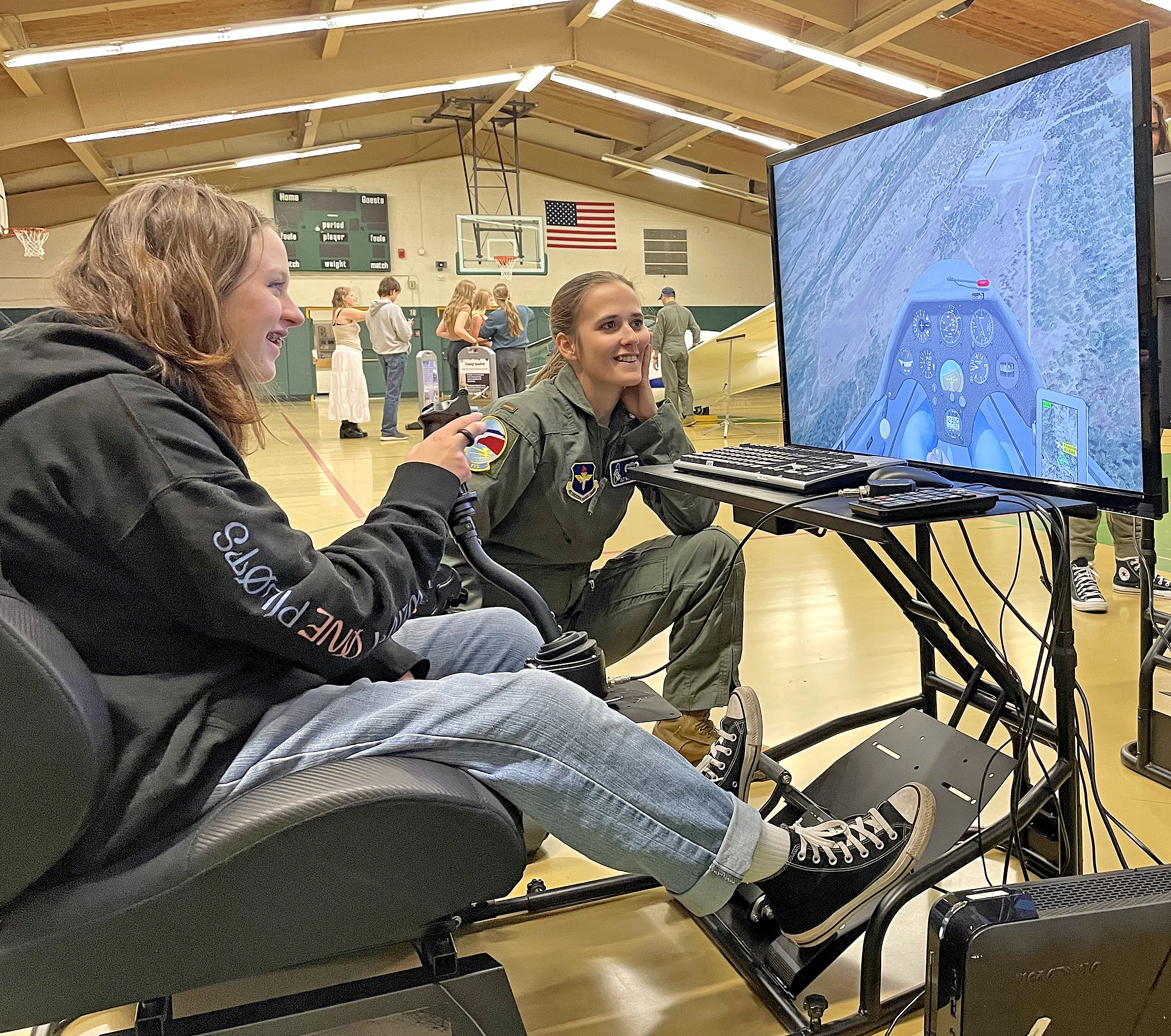 Photo Courtesy of Manitou Springs School District 14. Maya Scott takes the flight simulator for a spin as Lt. Nikita Webb watches.